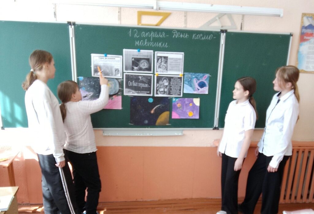 Ребята рассматривают рисунки ко дню космонавтики