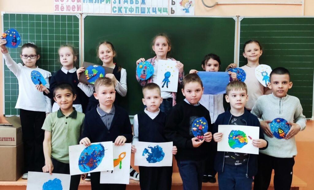 Ребята стоят у доски и держат в руках поделки из пластилина