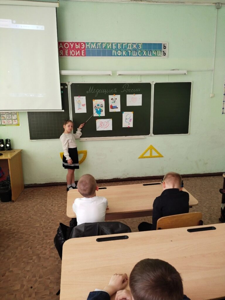 Ученица стоит у доски рассказывает о медицине в России