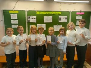 На фотографии ребята показывают памятки по цифровой безопасности