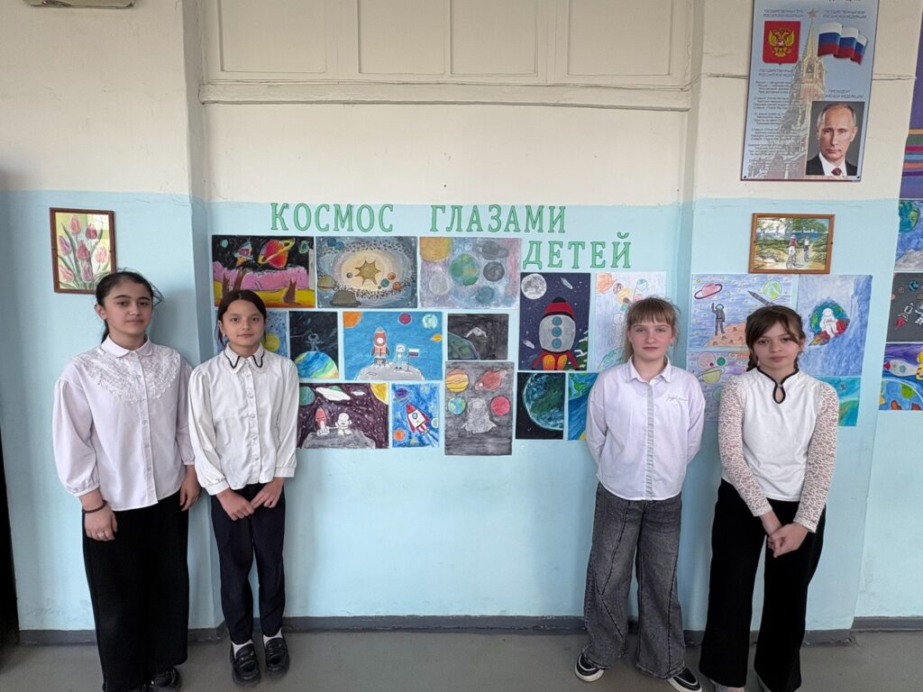 Ребята стоят около выставки рисунков "Космос глазами детей"