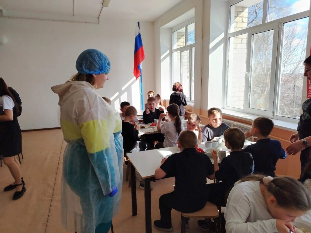 Родители наблюдают как ребята завтракают в столовой