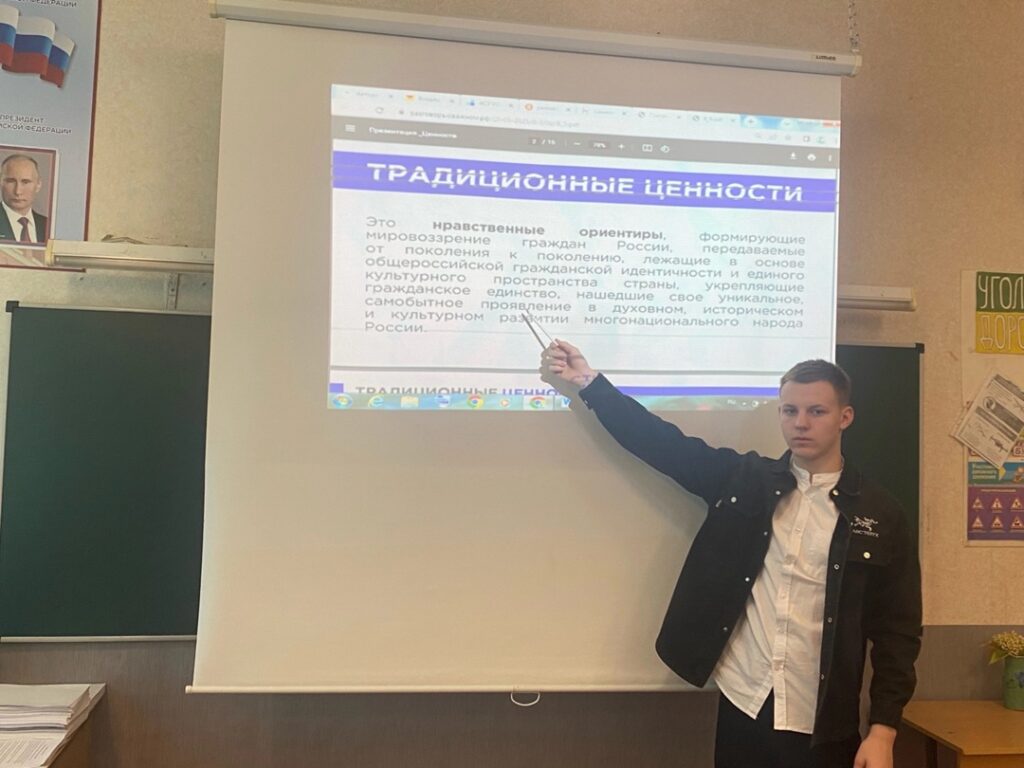 Ребенок стоит у экрана и показывает на него