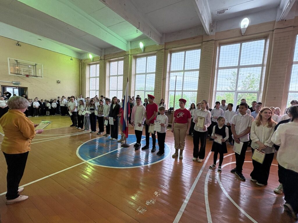Ребята стоят на торжественной линейке им вручают грамоты за хорошую учебу