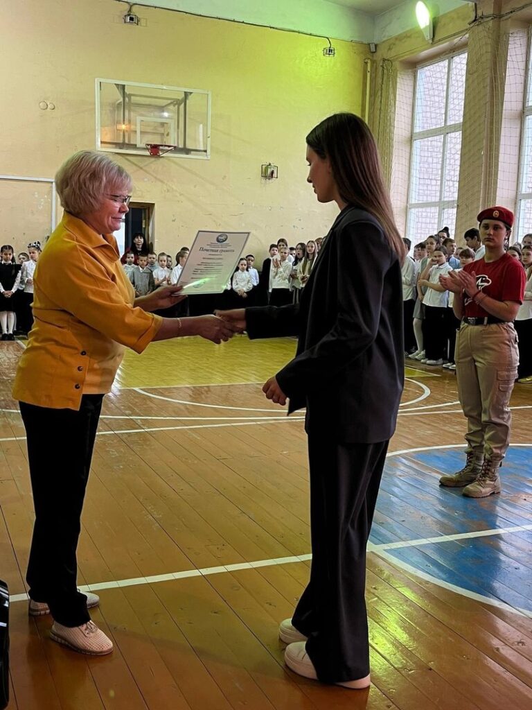 Директор школы Буртаева О.В. вручает ученице грамоту